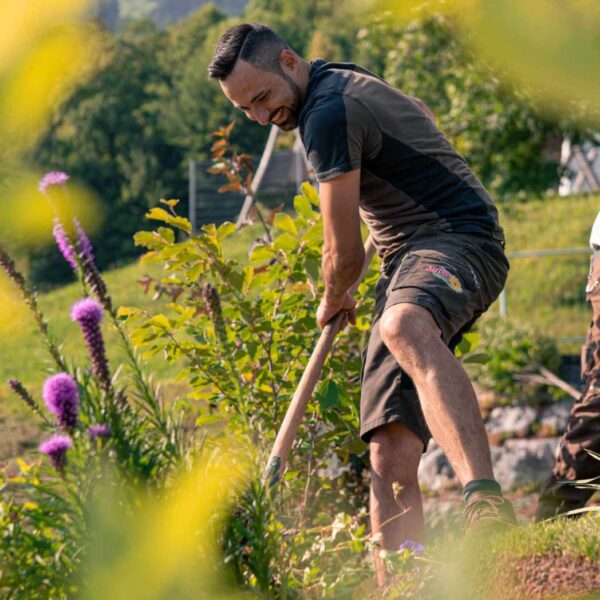 Ein Mann beim bearbeiten eines Gartenbeetes.